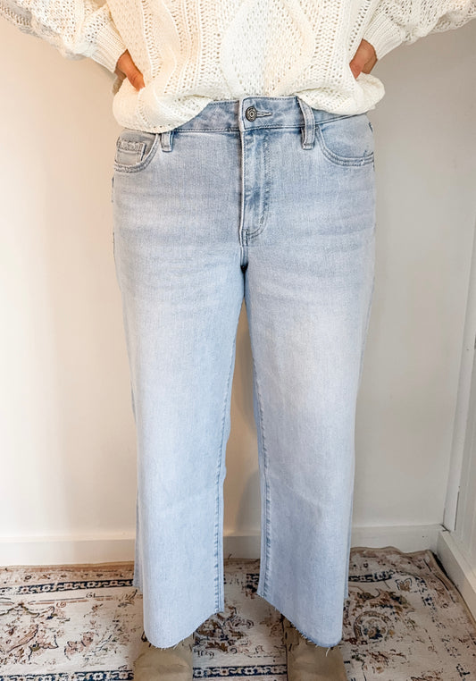 Light blue jeans worn by a person against a plain background