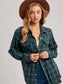 Woman wearing a plaid shirt and brown hat on a plain background